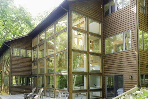 Large cedar-sided home surrounded by mature trees